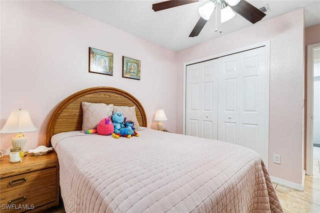 tiled bedroom with ceiling fan and a closet