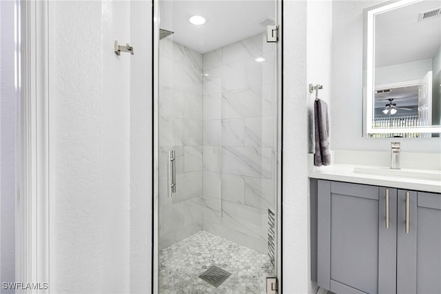 bathroom featuring ceiling fan, vanity, and an enclosed shower