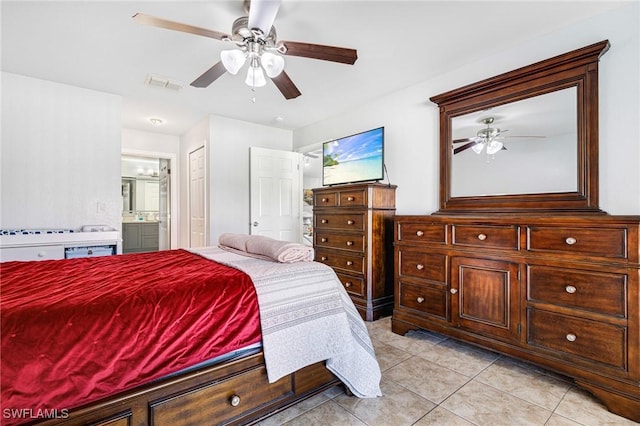 bedroom with ceiling fan, light tile patterned flooring, and connected bathroom