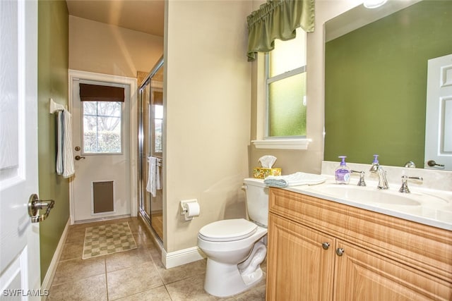 bathroom featuring a shower with door, toilet, vanity, and tile patterned flooring