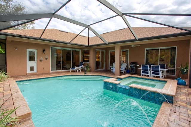 view of pool with an in ground hot tub, pool water feature, ceiling fan, and a patio