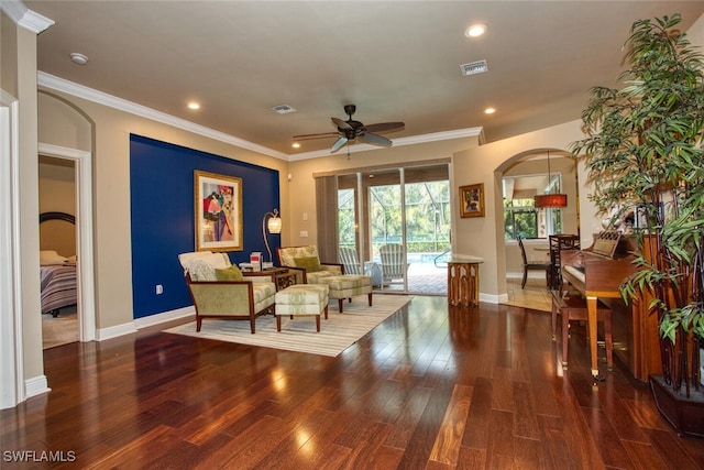 living area with ceiling fan, ornamental molding, and dark hardwood / wood-style floors