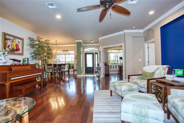 living room featuring dark hardwood / wood-style floors, ceiling fan with notable chandelier, and ornamental molding