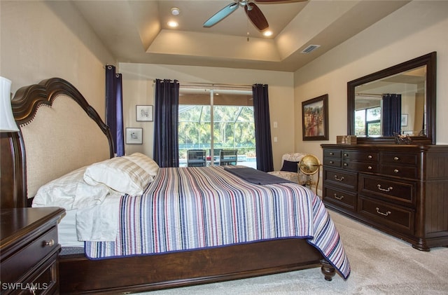 bedroom with light carpet, ceiling fan, access to outside, and a tray ceiling