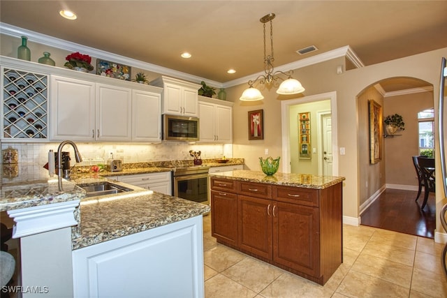 kitchen with appliances with stainless steel finishes, a center island, pendant lighting, white cabinets, and sink