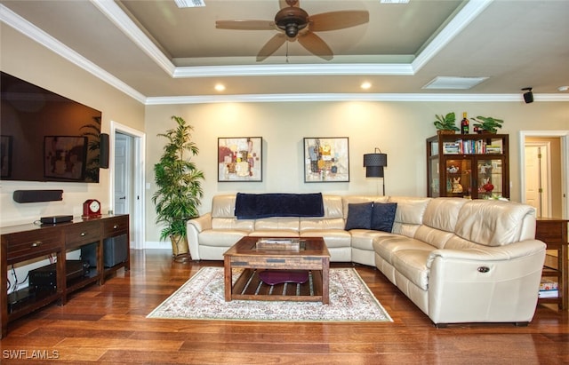 living room with ceiling fan, hardwood / wood-style floors, a tray ceiling, and ornamental molding