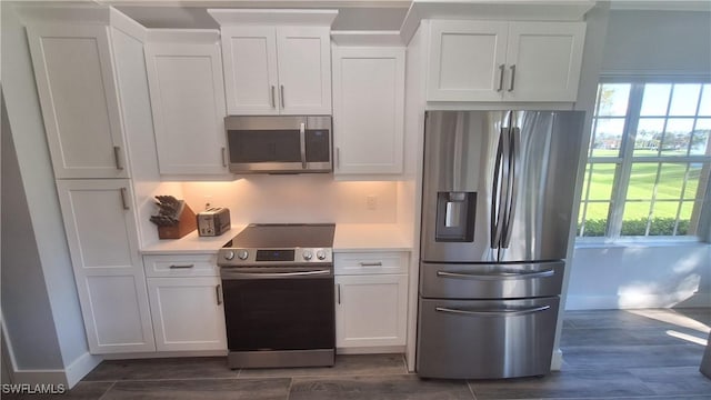 kitchen with white cabinets, stainless steel appliances, and dark hardwood / wood-style floors