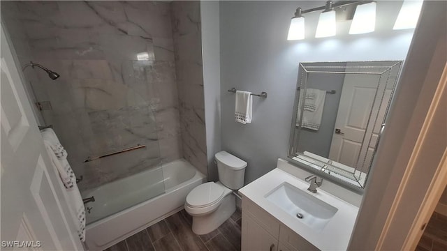 full bathroom featuring vanity, tiled shower / bath combo, and toilet