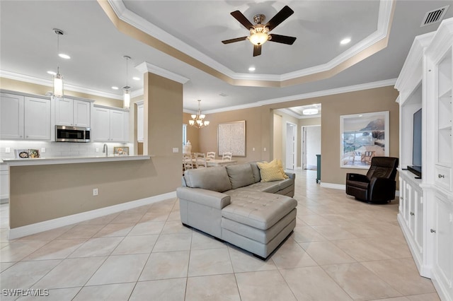 living area featuring a tray ceiling, light tile patterned flooring, visible vents, and crown molding