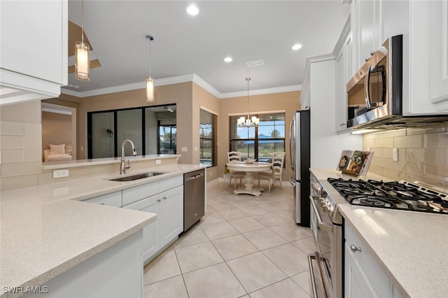 kitchen featuring a sink, stainless steel appliances, light countertops, and decorative light fixtures