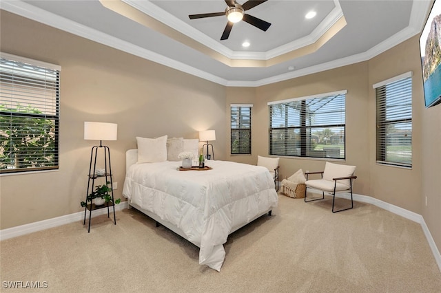 bedroom featuring a tray ceiling, light colored carpet, ornamental molding, multiple windows, and baseboards