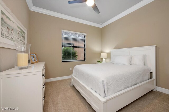 bedroom with light carpet, ceiling fan, baseboards, and crown molding