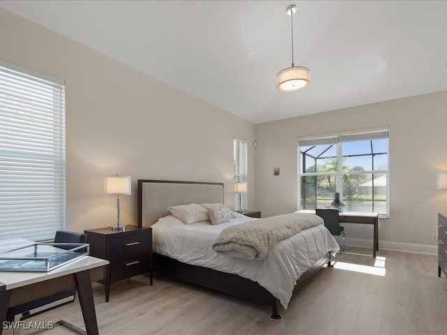 bedroom with baseboards and light wood finished floors