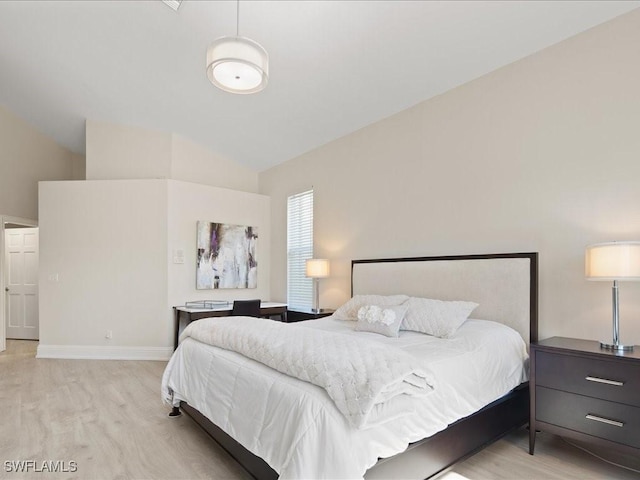 bedroom with vaulted ceiling, baseboards, and wood finished floors