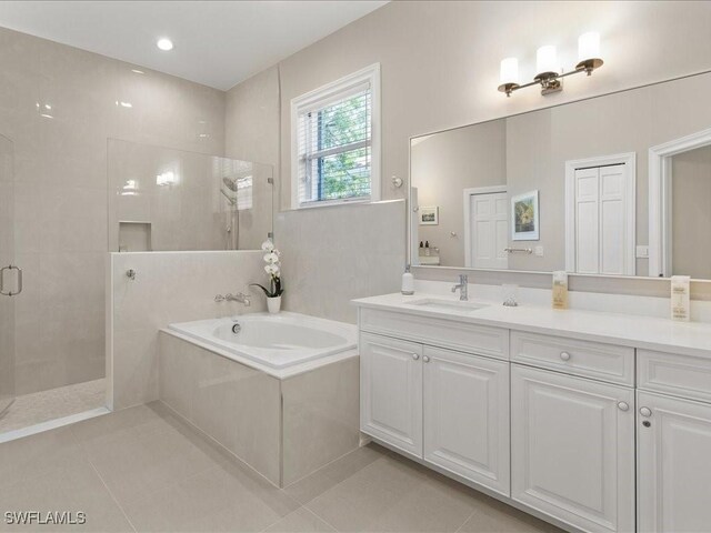 bathroom with vanity, a tile shower, a bath, and tile patterned floors