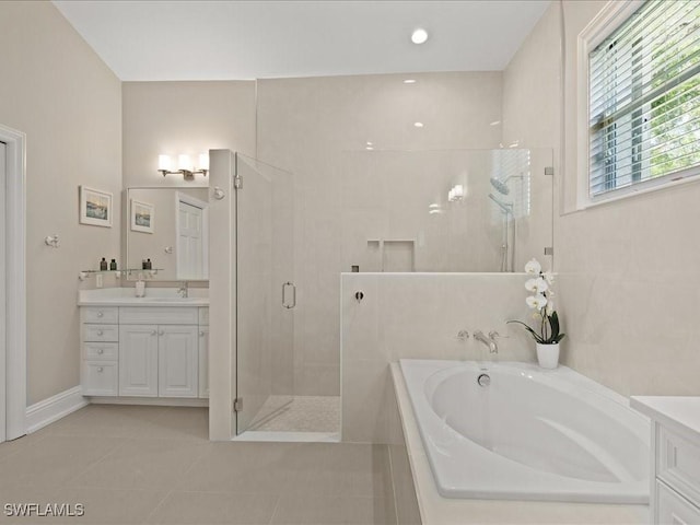 bathroom featuring a bath, a stall shower, tile patterned flooring, and vanity