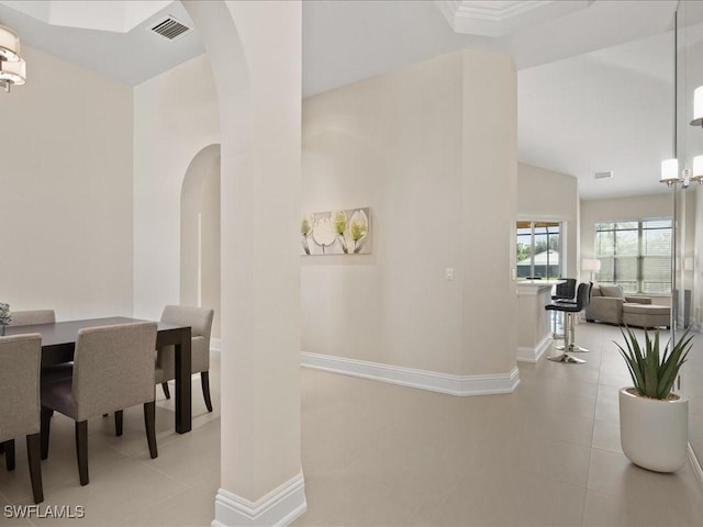 tiled dining area with arched walkways, visible vents, and baseboards