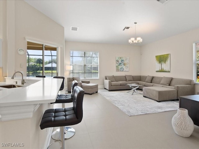 tiled living area with visible vents, a chandelier, and a sink