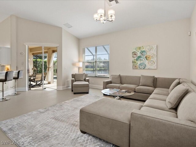 living room featuring a notable chandelier, visible vents, a healthy amount of sunlight, and lofted ceiling