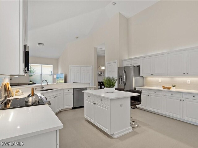 kitchen with visible vents, appliances with stainless steel finishes, white cabinetry, high vaulted ceiling, and a sink