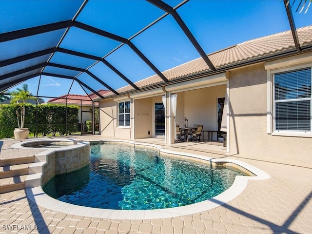 view of pool with glass enclosure, a pool with connected hot tub, and a patio