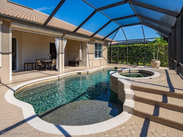 view of swimming pool with a pool with connected hot tub, a patio area, and a lanai