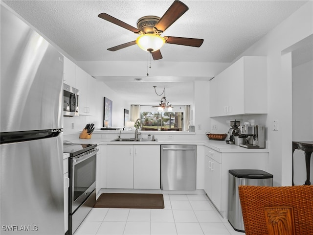 kitchen featuring sink, white cabinets, light tile patterned floors, a textured ceiling, and stainless steel appliances