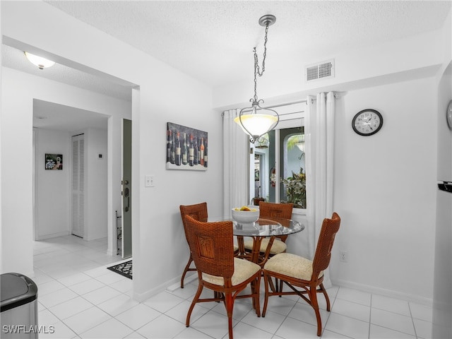 tiled dining area featuring a textured ceiling