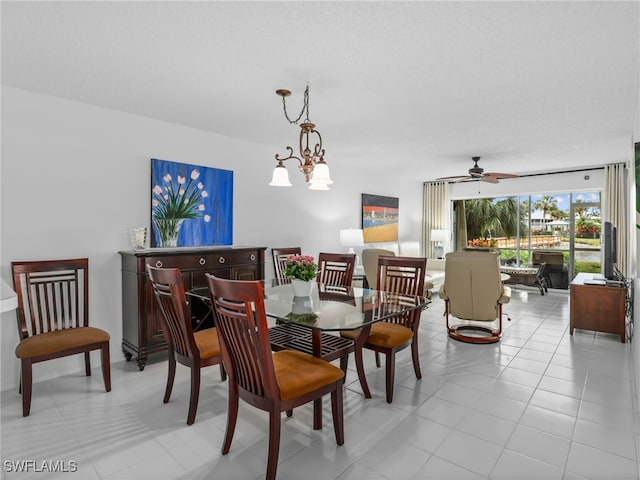 tiled dining area with ceiling fan with notable chandelier