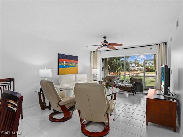 tiled living room featuring ceiling fan and a textured ceiling