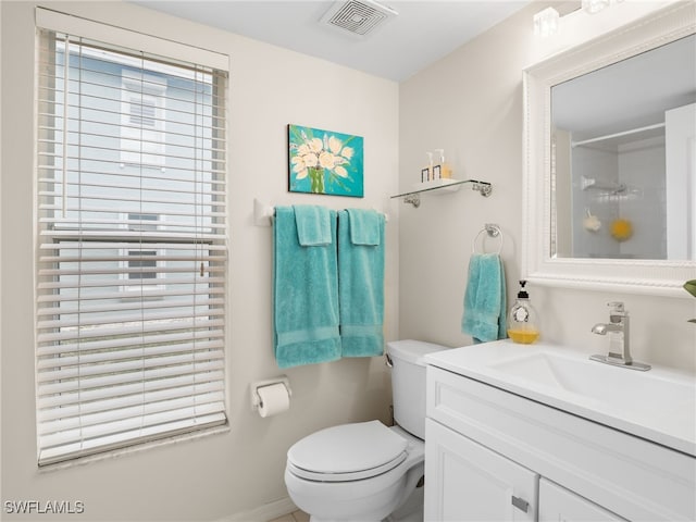 bathroom with toilet, walk in shower, and vanity