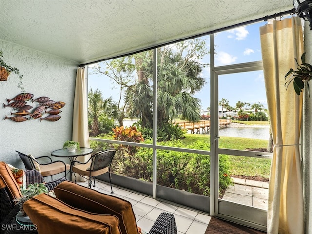 sunroom / solarium featuring a water view