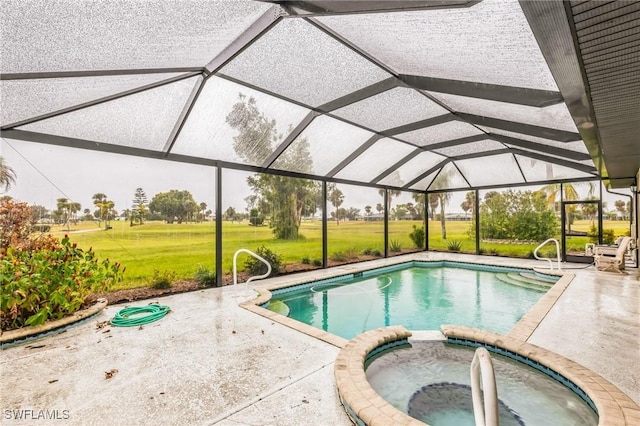 view of pool featuring a yard, a patio area, an in ground hot tub, and glass enclosure