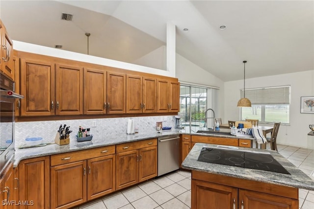 kitchen with brown cabinets, appliances with stainless steel finishes, and light stone countertops