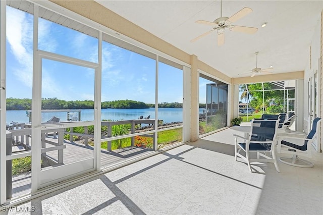 sunroom / solarium featuring ceiling fan, a water view, and a wealth of natural light