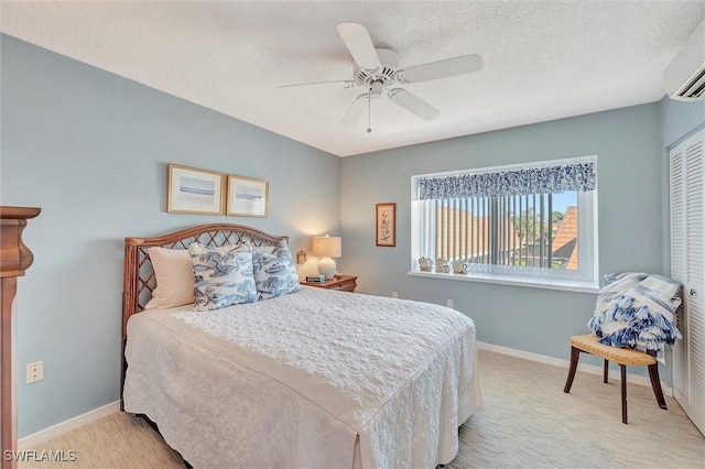 bedroom featuring a closet, a wall mounted AC, light colored carpet, ceiling fan, and a textured ceiling