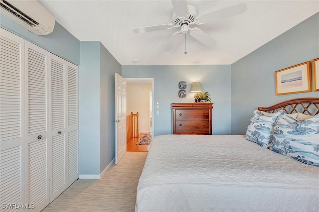 bedroom with ceiling fan, light colored carpet, a wall mounted air conditioner, and a closet