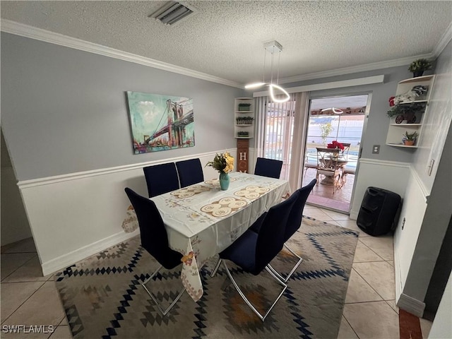 tiled dining area with crown molding and a textured ceiling