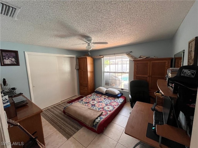 tiled bedroom featuring a textured ceiling, a closet, and ceiling fan