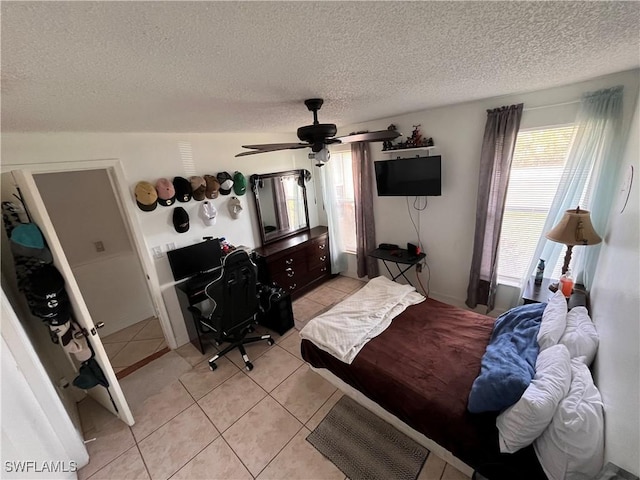 tiled bedroom featuring a textured ceiling and ceiling fan