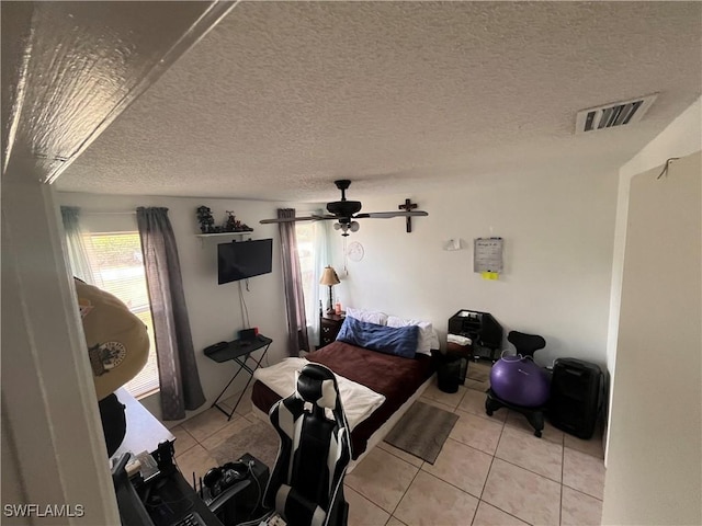 living room featuring ceiling fan, a textured ceiling, and light tile patterned floors