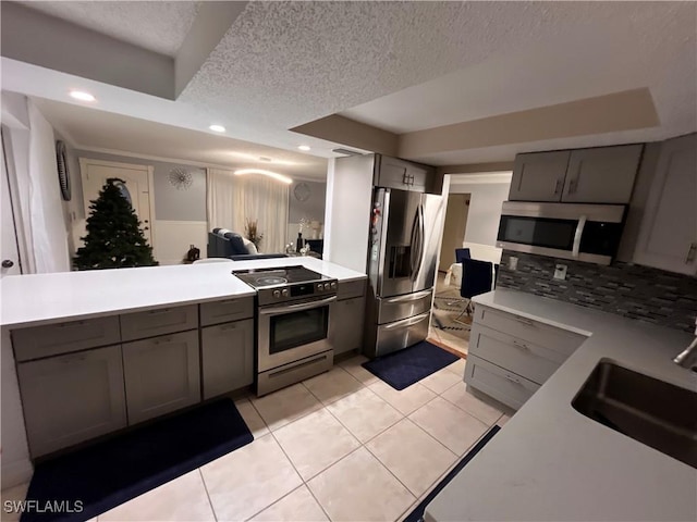 kitchen with sink, gray cabinetry, a textured ceiling, light tile patterned floors, and appliances with stainless steel finishes