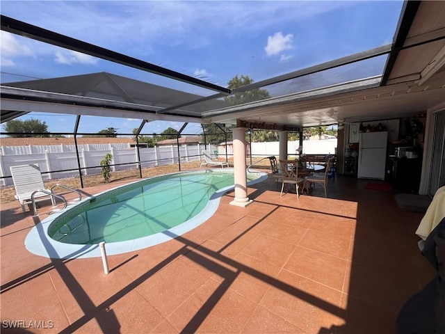 view of pool with a patio and glass enclosure