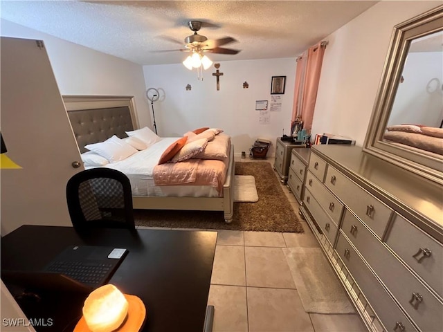 tiled bedroom with ceiling fan and a textured ceiling