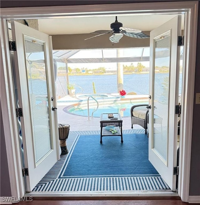 interior space featuring ceiling fan, plenty of natural light, and a water view