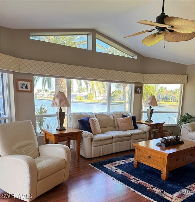 living room with ceiling fan, dark hardwood / wood-style flooring, a water view, and vaulted ceiling