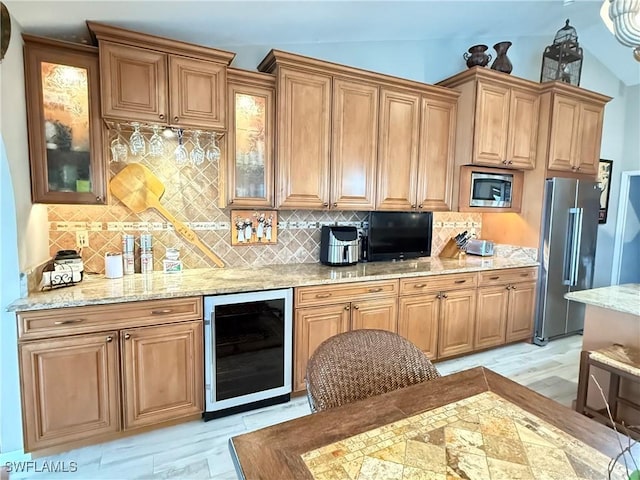 kitchen featuring decorative backsplash, stainless steel appliances, light hardwood / wood-style floors, wine cooler, and lofted ceiling