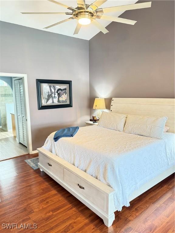 bedroom with ensuite bath, ceiling fan, and dark wood-type flooring