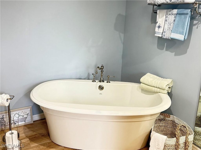 bathroom with wood-type flooring and a bathtub