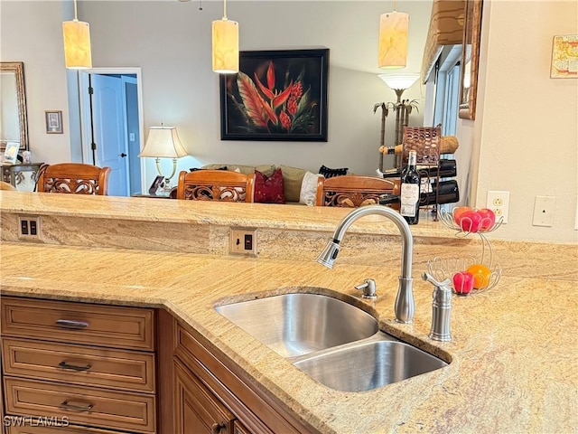 kitchen with light stone countertops, decorative light fixtures, and sink